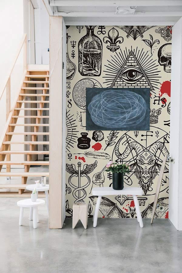 Vintage occult-themed wallpaper, industrial room, concrete floor, wooden staircase, modern chair, decorative board.