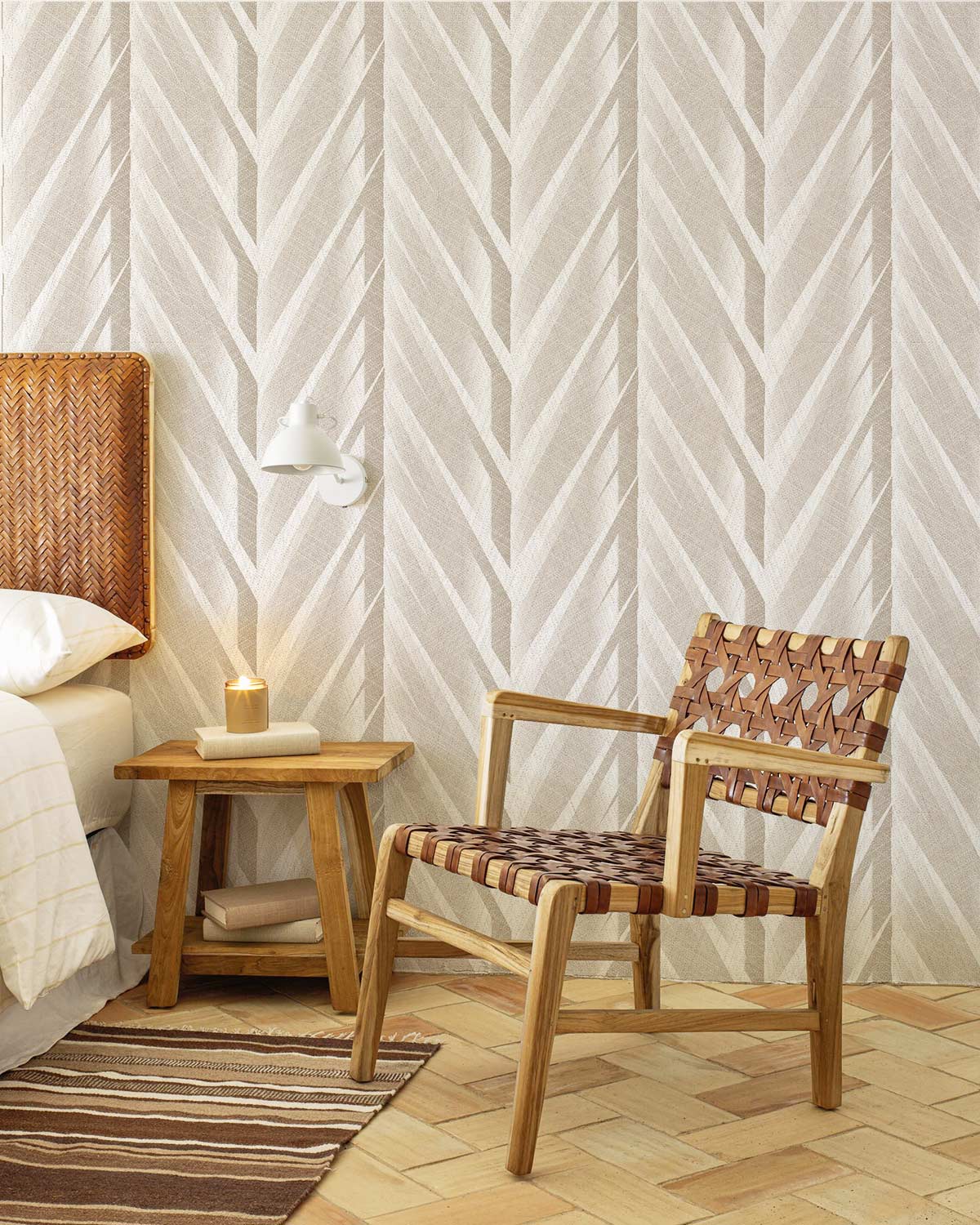 Elegant neutral chevron wallpaper with wooden chair, tan headboard, hardwood floor in modern bedroom.
