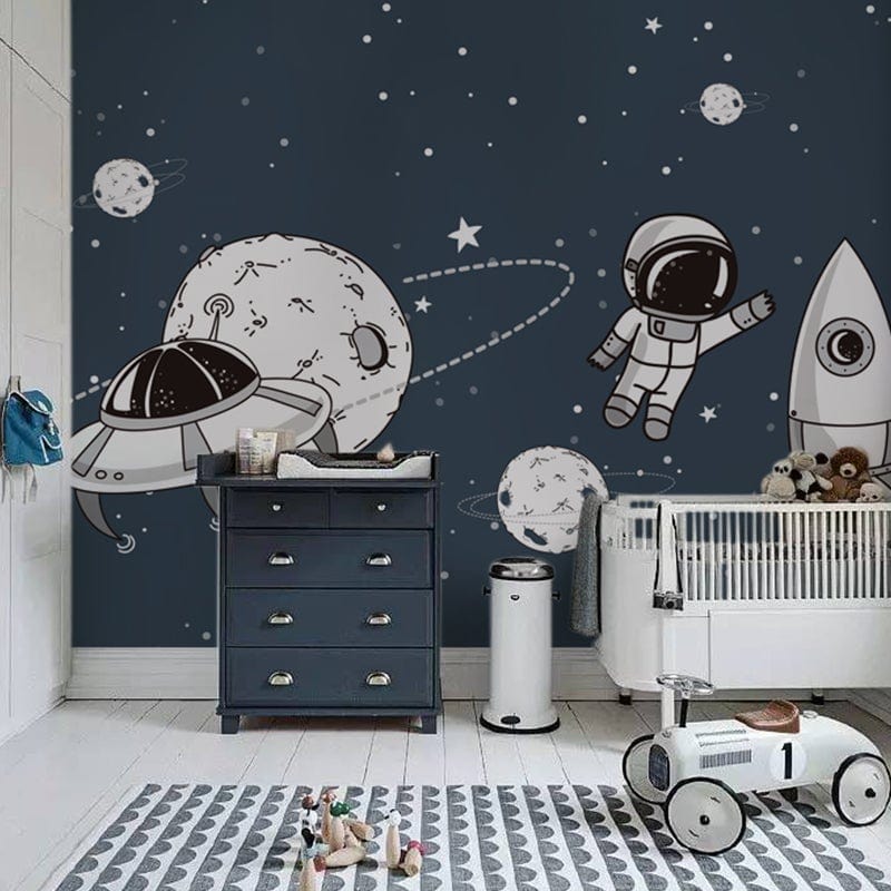 Navy children's room with space-themed wallpaper, white cot, dark chest of drawers, and wooden flooring.