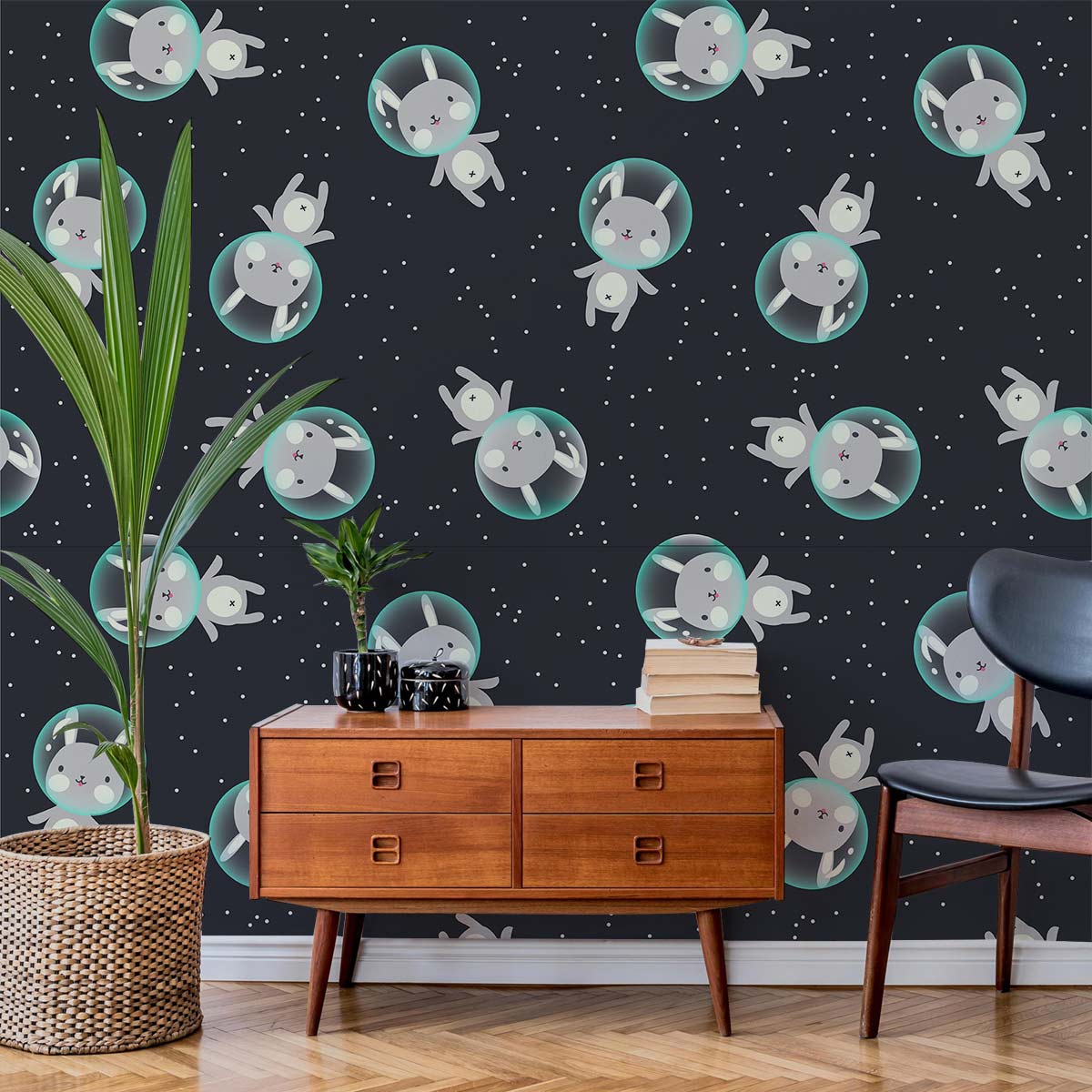 Whimsical wallpaper with grey space bunnies decorates children's bedroom; mid-century brown dresser, parquet flooring.