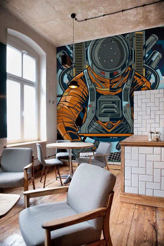 Retro Astronaut Space Adventure mural wallpaper, orange-blue, in modern café with wooden flooring, grey chairs.