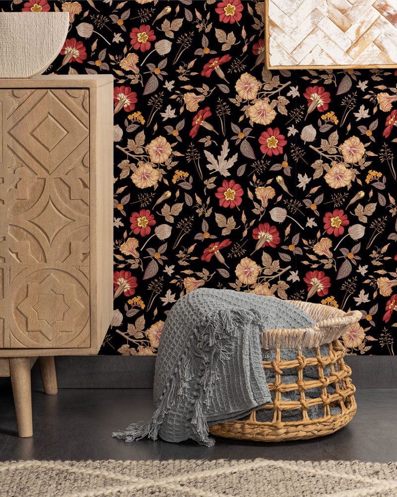 Vintage floral black mural wallpaper with red and gold blossoms, wooden sideboard, basket, grey rug.