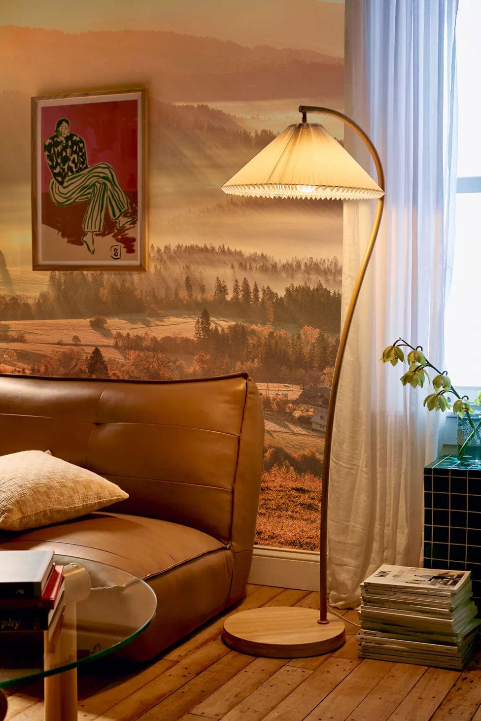Serene Sunrise Misty Valley mural wallpaper, leather sofa, wooden flooring, floor lamp, and framed artwork.