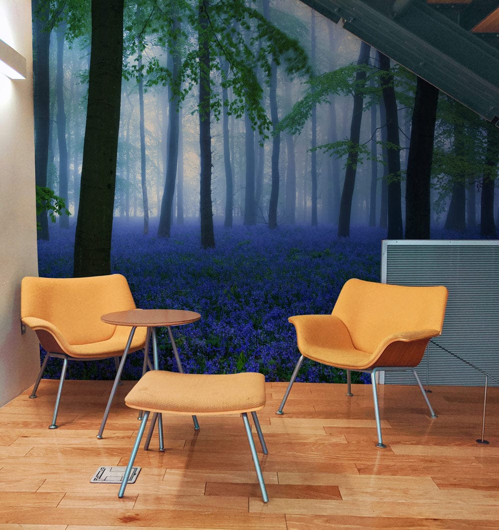 Enchanting woodland mural wallpaper in misty forest scene, orange chairs, wooden floor, modern decor.