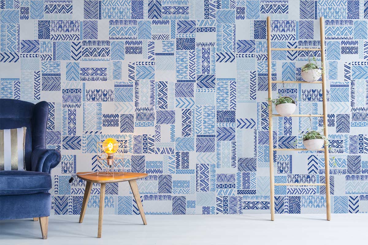 Contemporary blue geometric tribal wallpaper, modern interiors, dark blue armchair, light wooden flooring, ladder shelf.
