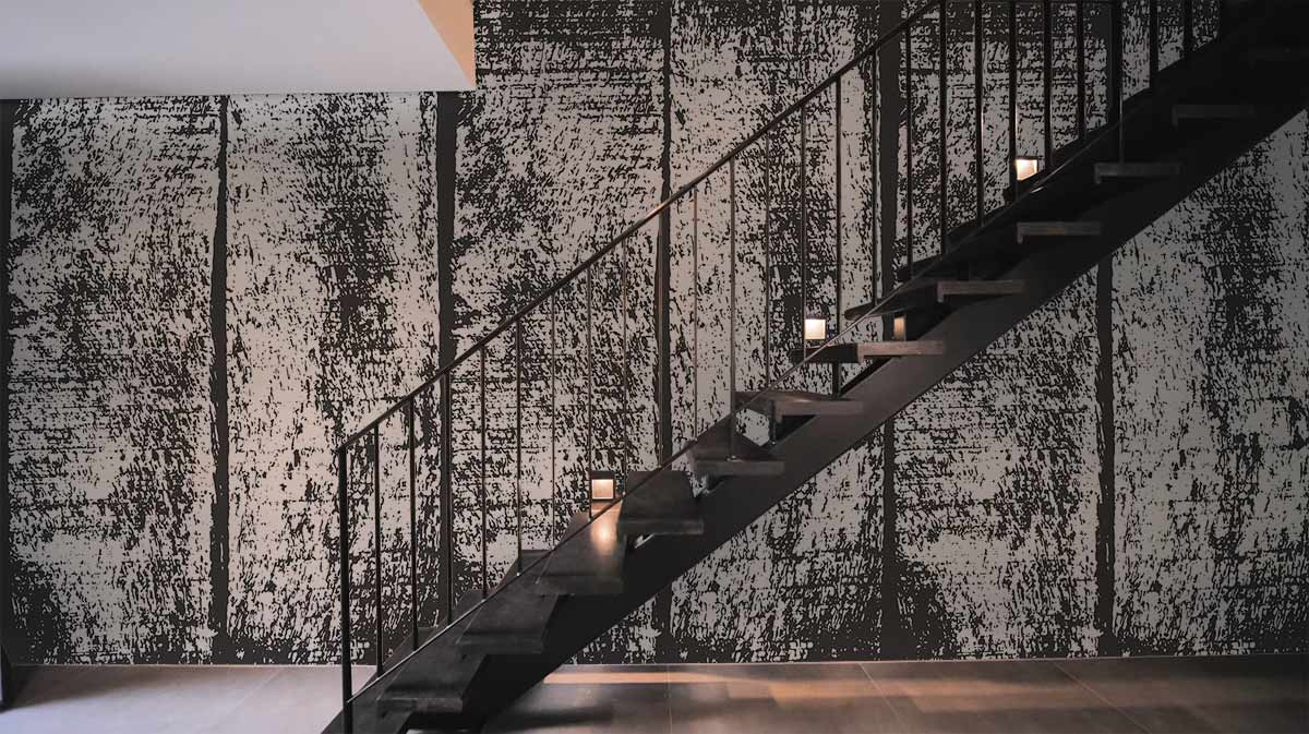 Rustic textured wallpaper with black metal staircase; wood-effect wallpaper enhances modern interior design style.