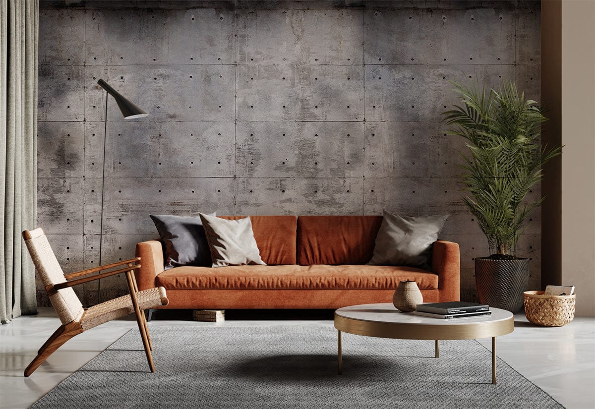 Industrial grey concrete-effect wallpaper; modern urban interior with rust sofa, textured wall, armchair, round table.