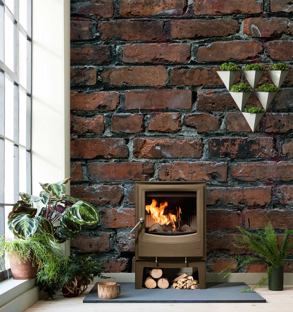 Vintage red brick wallpaper mural in cosy living room with rustic stove and green wall planters.