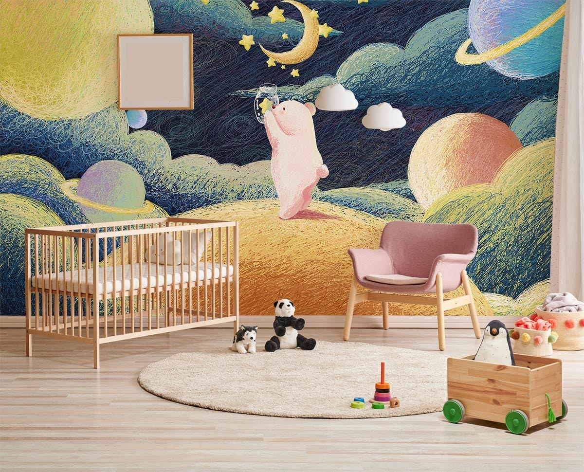 Whimsical Cosmic Bear mural wallpaper; nursery with pastel theme; pink chair; light wood crib; rug.