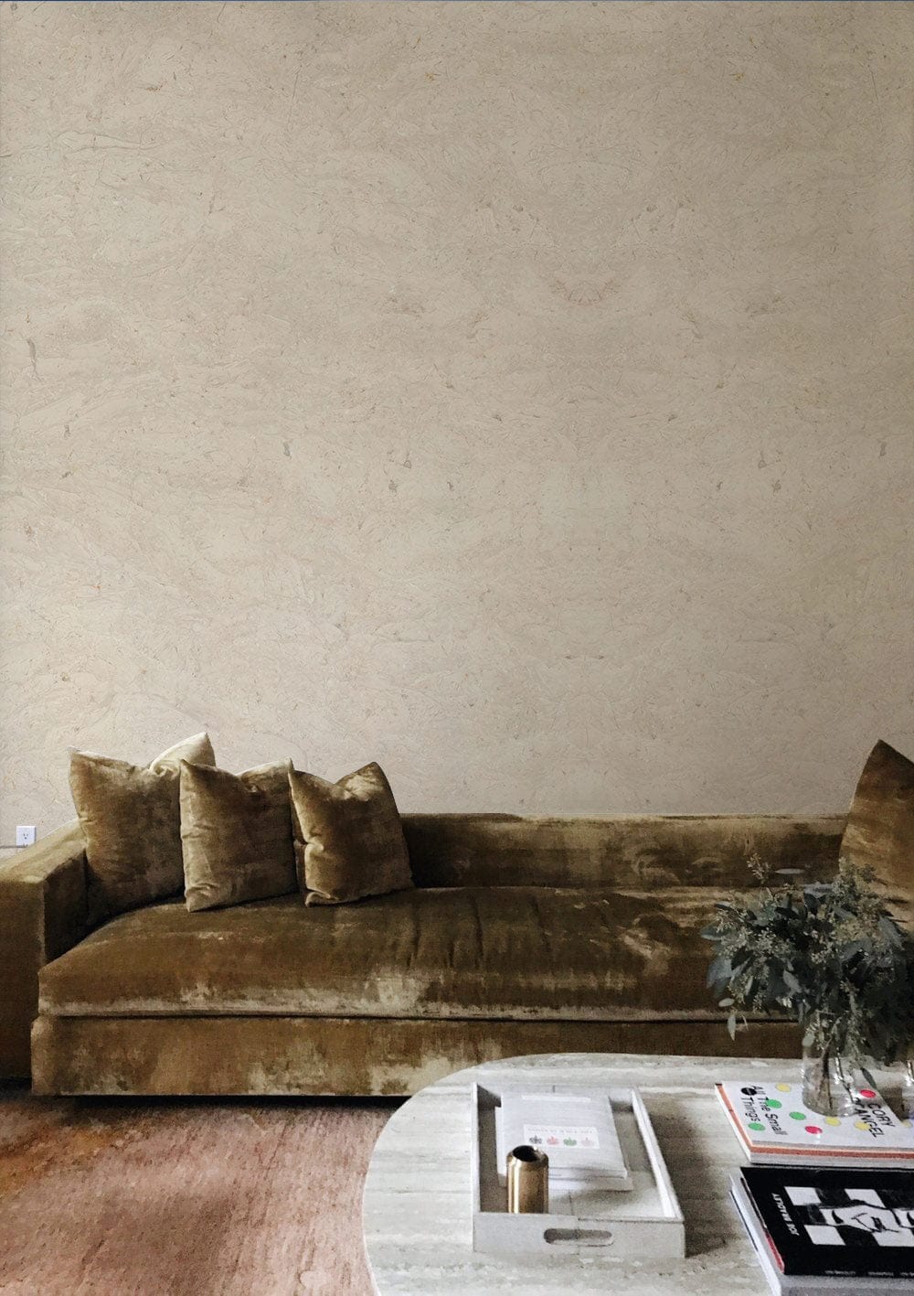 Elegant Beige Textured Marble Effect Wallpaper in living room with brown velvet sofa and wooden flooring.