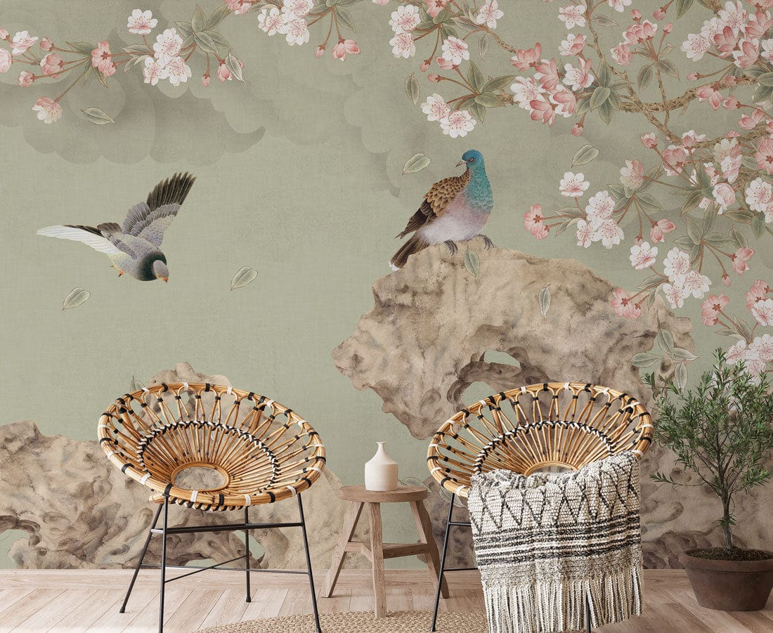 Serene Pastels Mural Wallpaper with birds, cherry blossoms, wicker chairs, rustic table in living room.