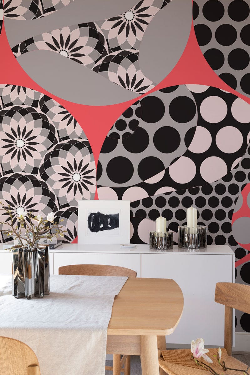 Retro geometric circles wallpaper in pink, black, grey; modern dining setup with wooden table and chairs.