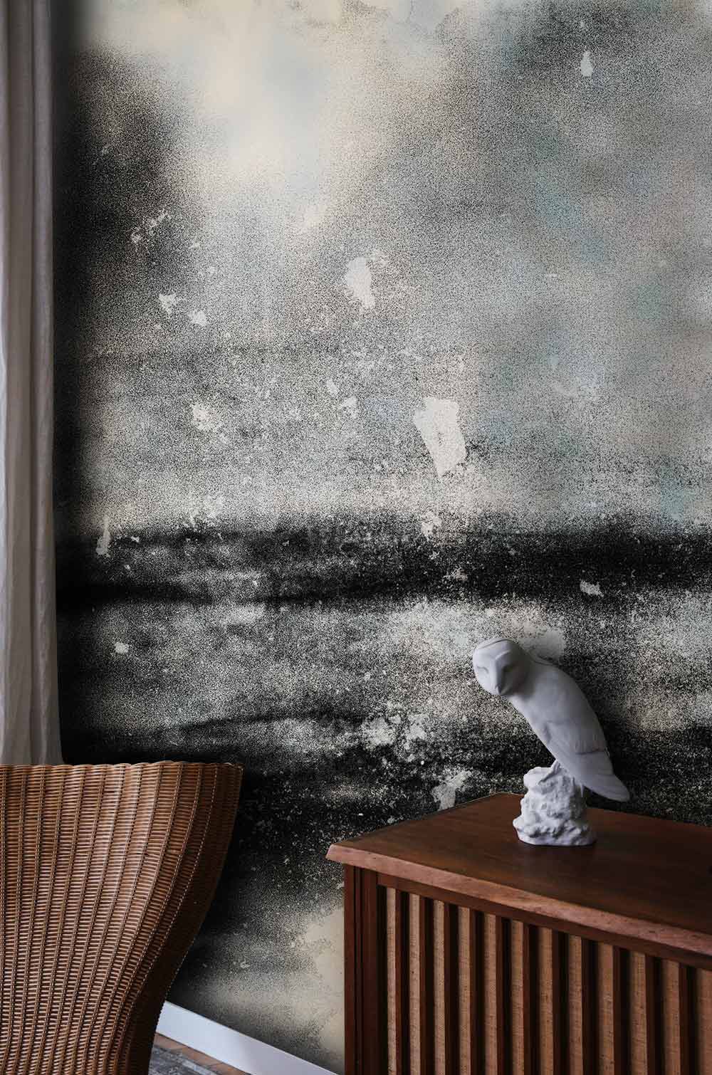 Monochrome grunge mural wallpaper with wicker chair, wooden console, and abstract decor in stylish interior.