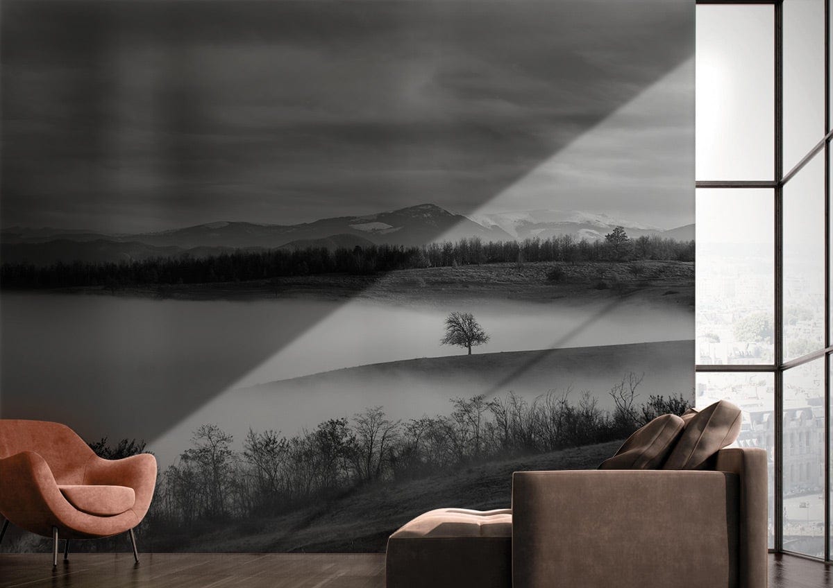 Monochrome Misty Mountain mural wallpaper, serene nature Décor; brown armchair, grey sofa, modern living room.