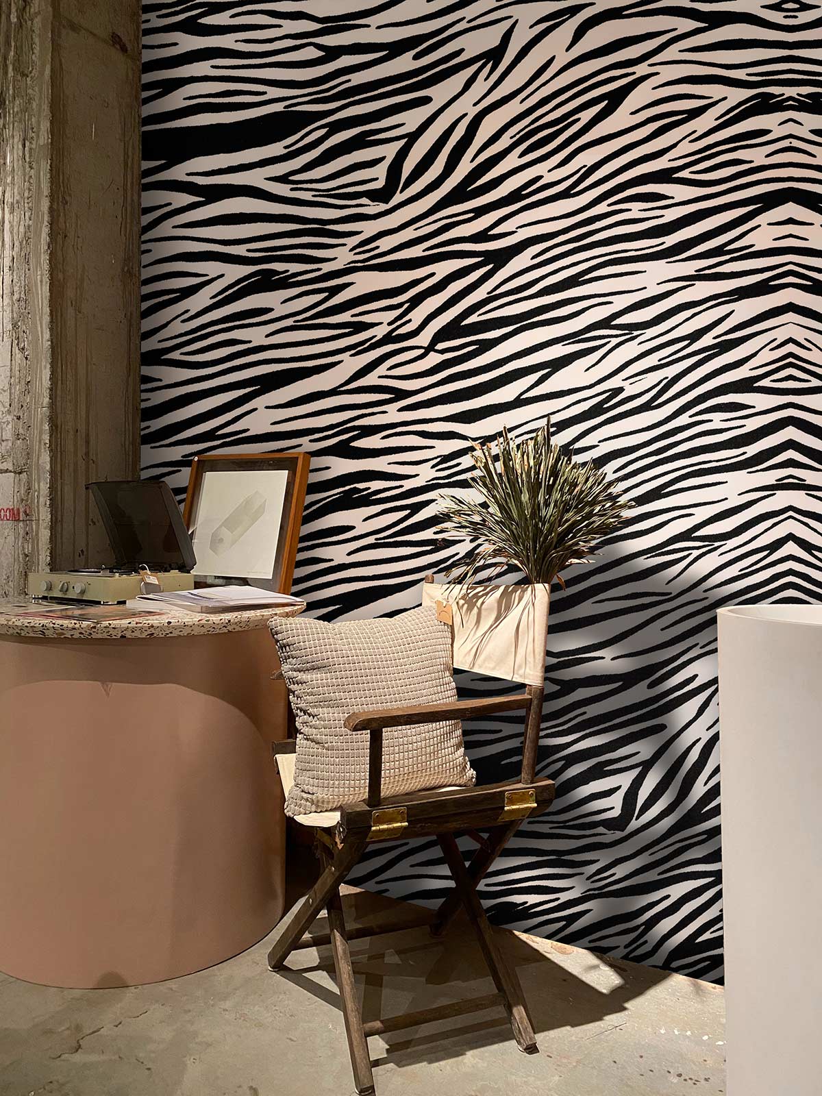 Monochrome zebra stripe wallpaper with wooden chair, beige cushion, and round table in stylish room.