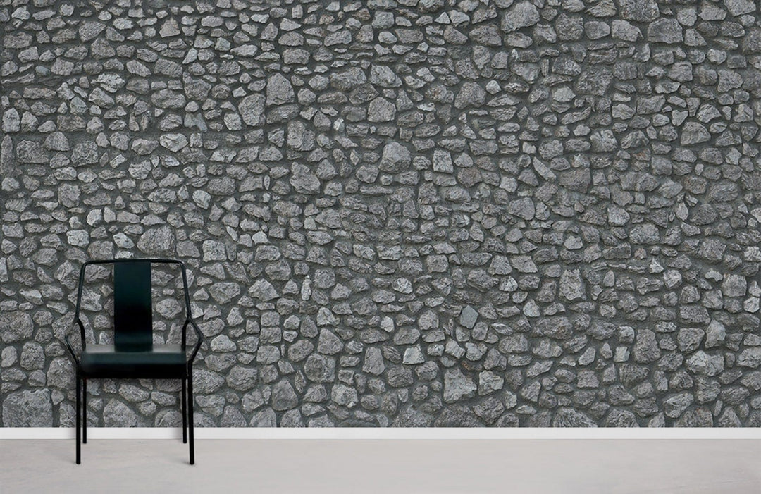 Rustic stone wall effect grey wallpaper complements industrial chair; ideal for modern interiors.