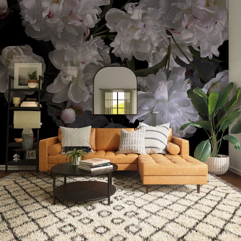 Elegant white peony floral wallpaper with dark background; features orange sofa, chevron rug, and mirror.