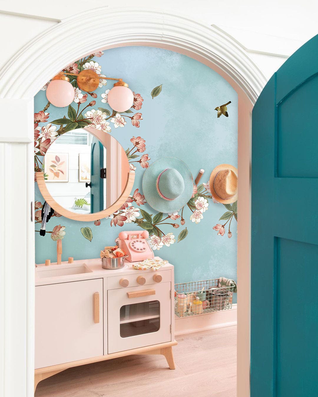 Tranquil Sky Blossom mural wallpaper in pastel tones, with kids' play kitchen, wooden floor, teal door.