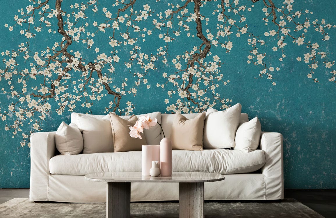 Teal Blossom Branches Wallpaper Mural with white sofa, beige cushions, and wooden table in living room.