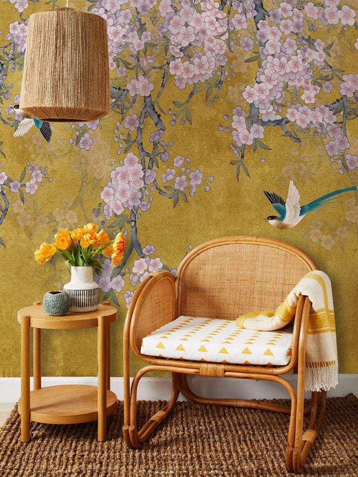 Elegant Floral Mural Wallpaper with wicker chair, side table, and woven lamp in a cosy room.