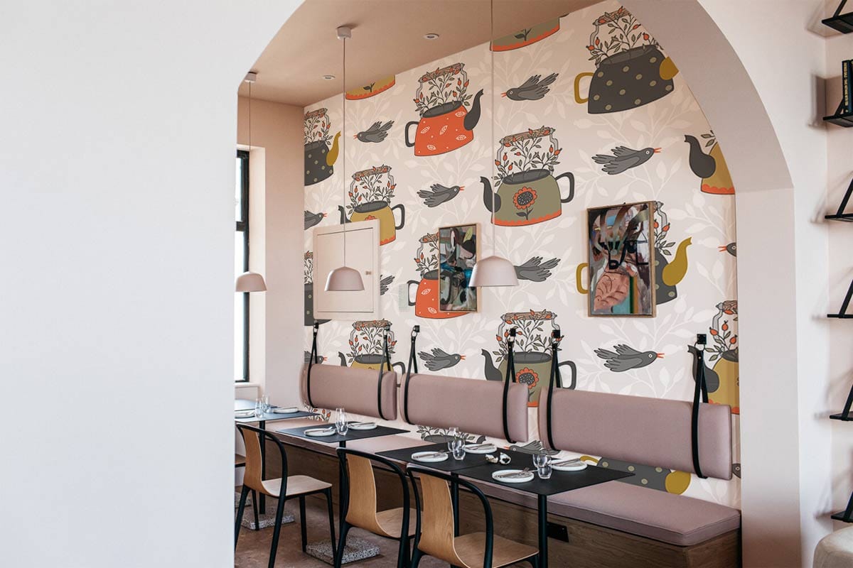 Vintage teapot bird wallpaper in earthy tones, dining room with pendant lights, mixed seating style.