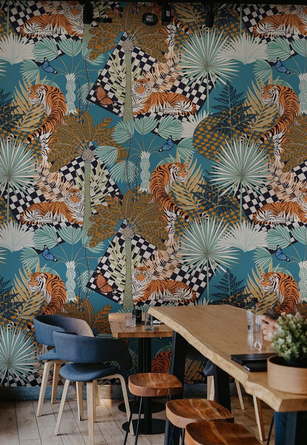 Exotic Jungle Safari wall mural in cafe with blue chairs, wooden tables, and patterned wallpaper.