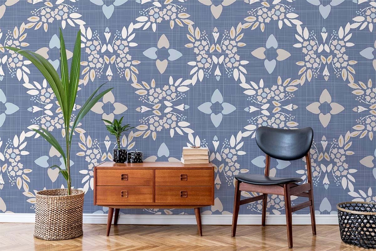 Vintage blue geometric floral wallpaper with wooden sideboard, black chair, parquet flooring, and indoor plant.
