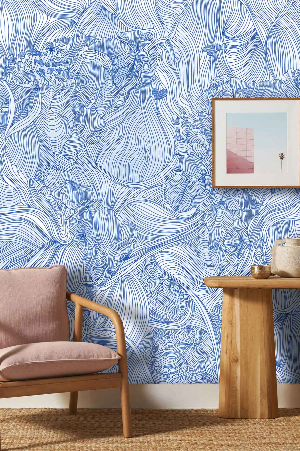 Elegant blue floral line art wallpaper in living room with beige armchair and wooden side table.