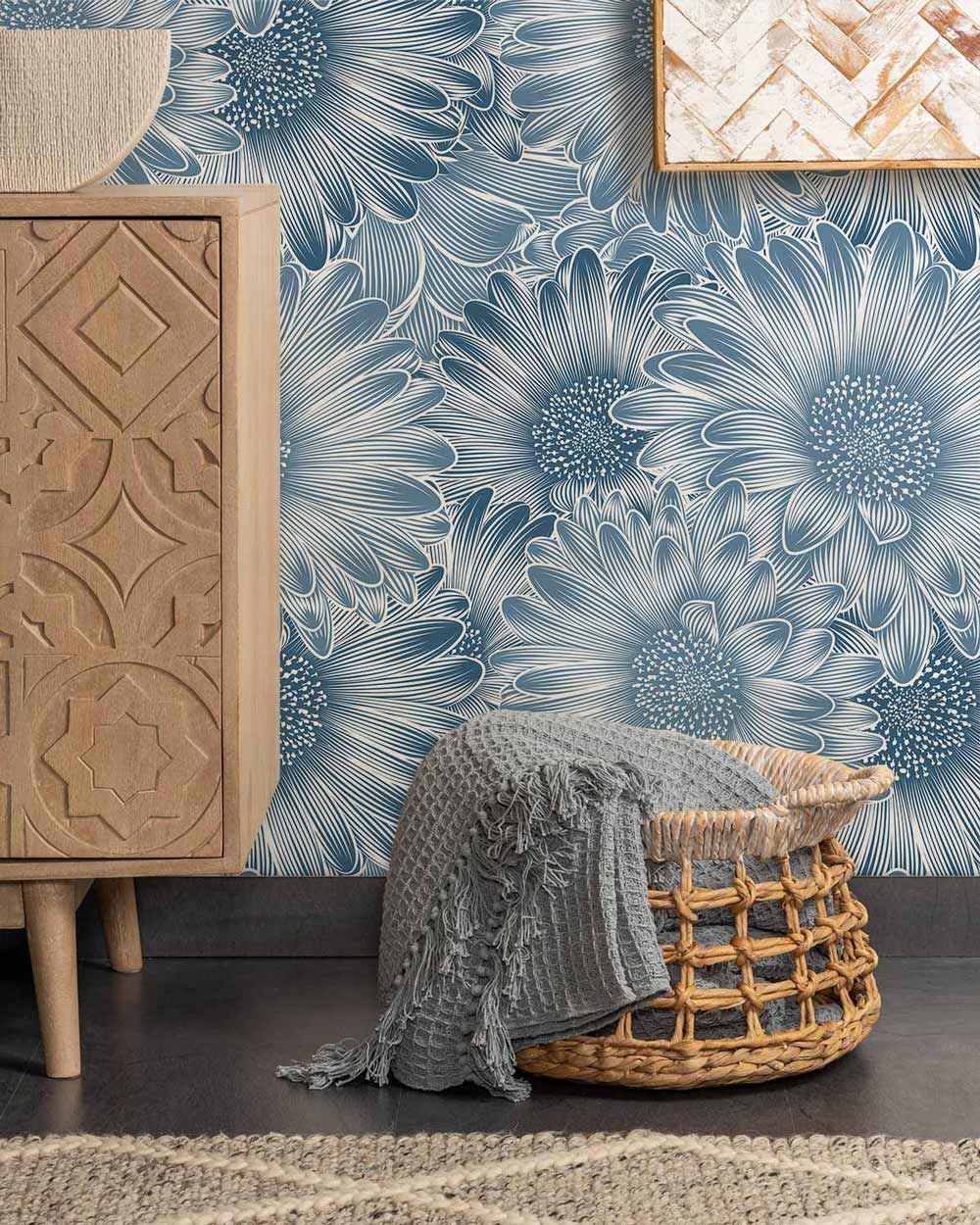 Elegant blue floral wallpaper in room with carved wooden cabinet, grey flooring, and woven basket decor.