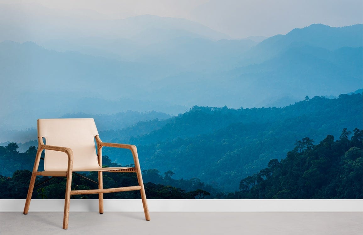Misty blue mountain landscape mural wallpaper in room with beige wooden chair, light flooring, calming interior.