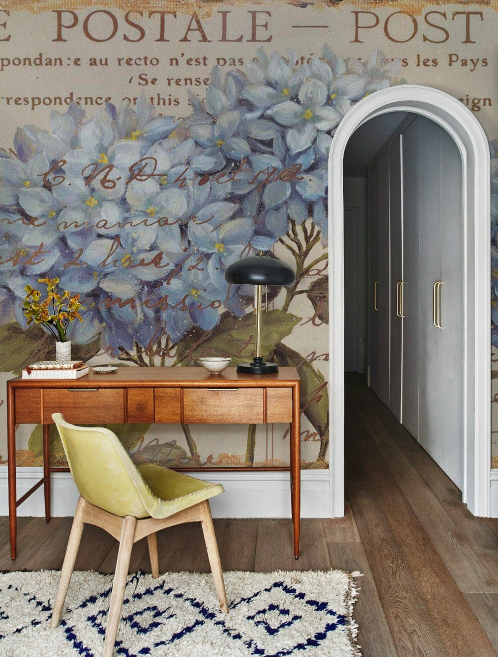 Vintage Blue Hydrangea Postcard Mural Wallpaper in hallway with wooden desk, green chair, white rug.