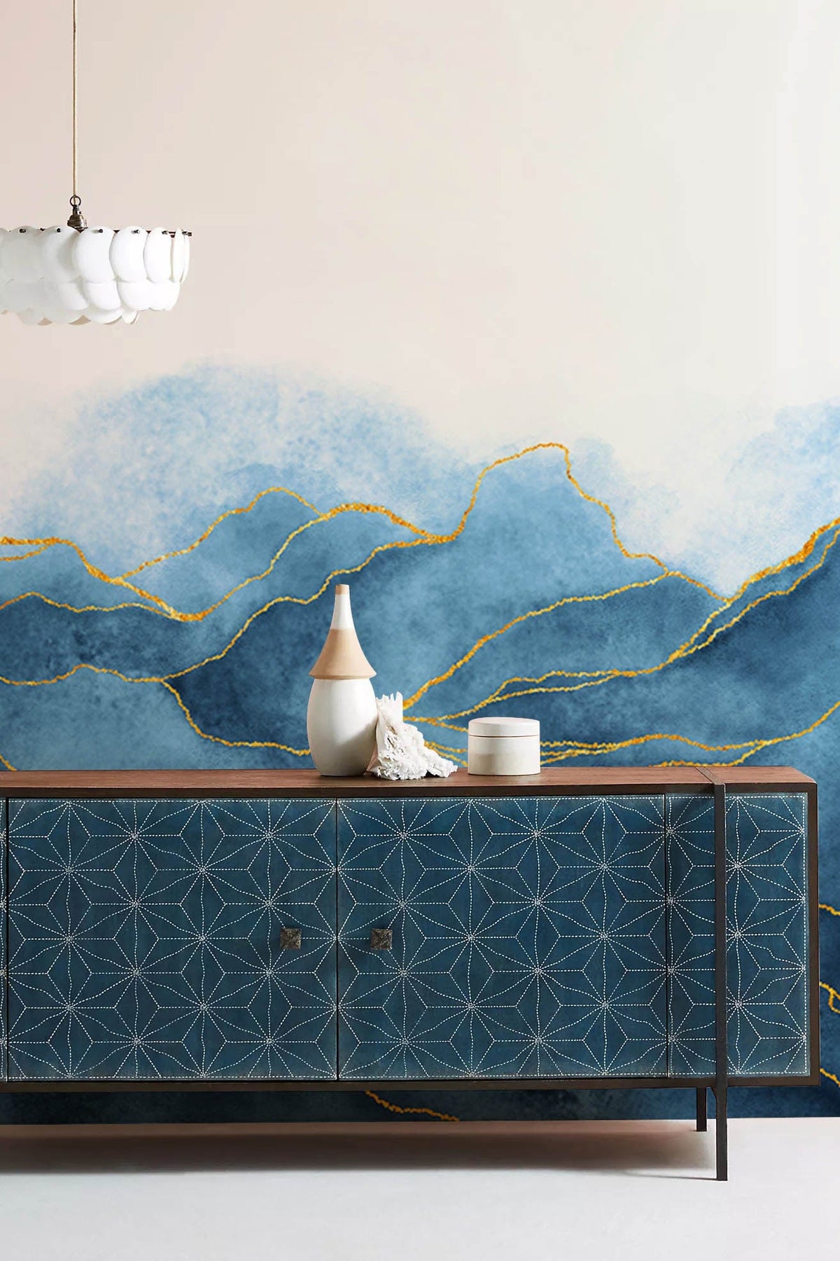 Luxury Blue Gold Abstract Mountain Wallpaper with geometric sideboard and pendant light in modern room.