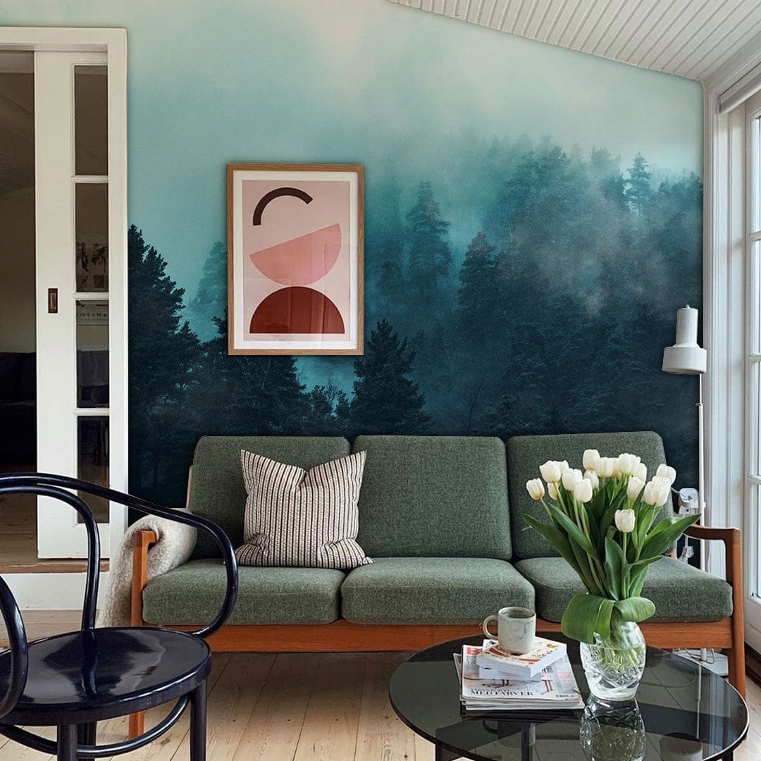 Enchanted Misty Forest mural in teal tones, green mid-century sofa, light wooden flooring, living room.