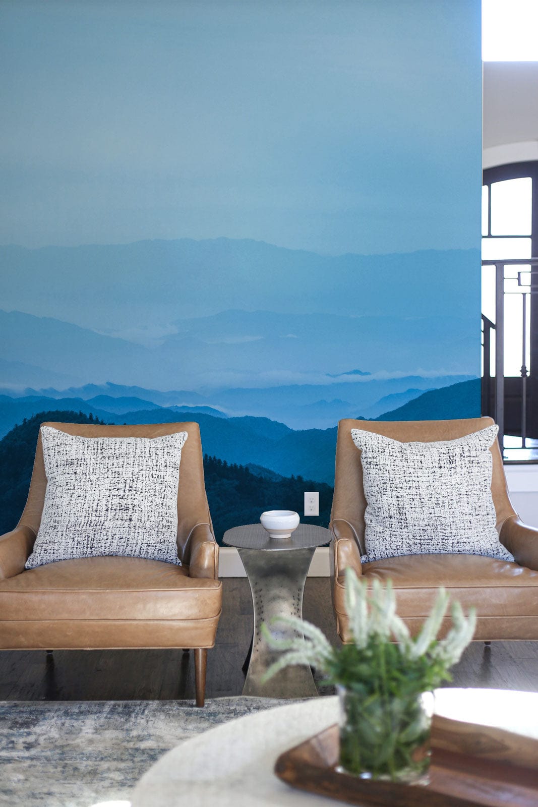 Serene Blue Mountain Mist mural with beige armchairs and grey flooring in modern living space.