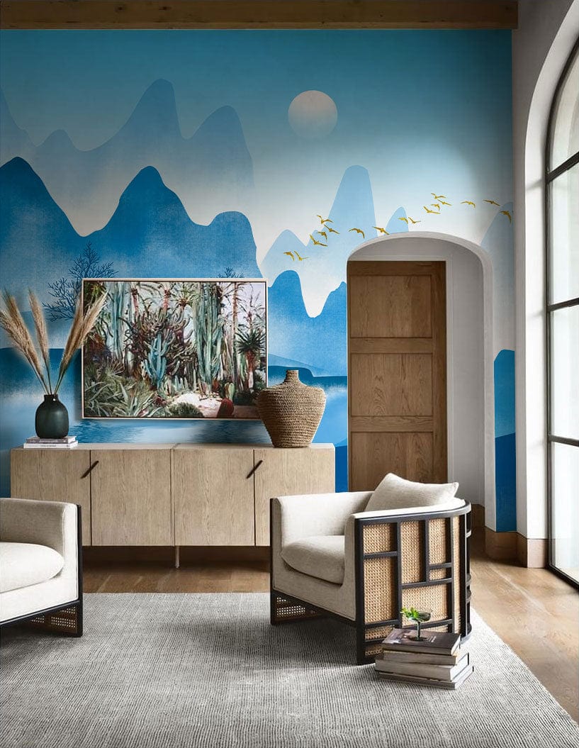 Serene blue mountain mural wallpaper in elegant living room with beige armchairs and wooden flooring.
