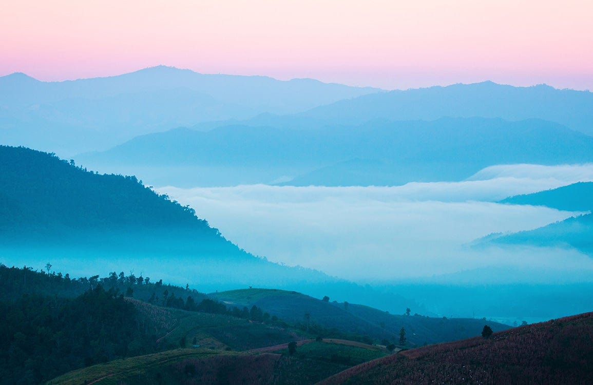 Tranquil Misty Mountain Landscape Wallpaper in Soft Pastel Blue Hues