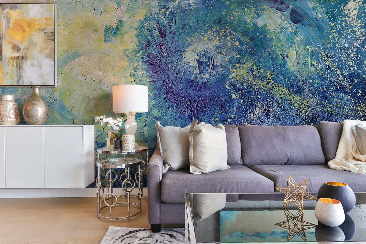 Abstract oceanic mural wallpaper in blue and green, grey sofa, glass table, light wood flooring.