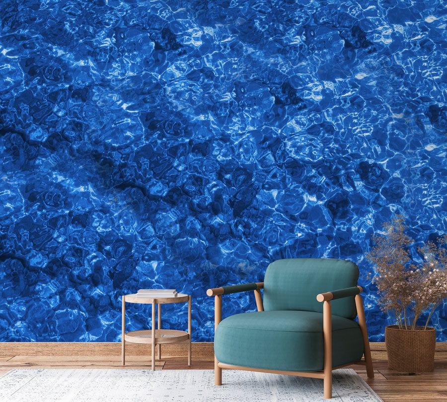 Deep Blue Ocean Ripple Mural Wallpaper, teal armchair, wooden side table, cosy living room decor.