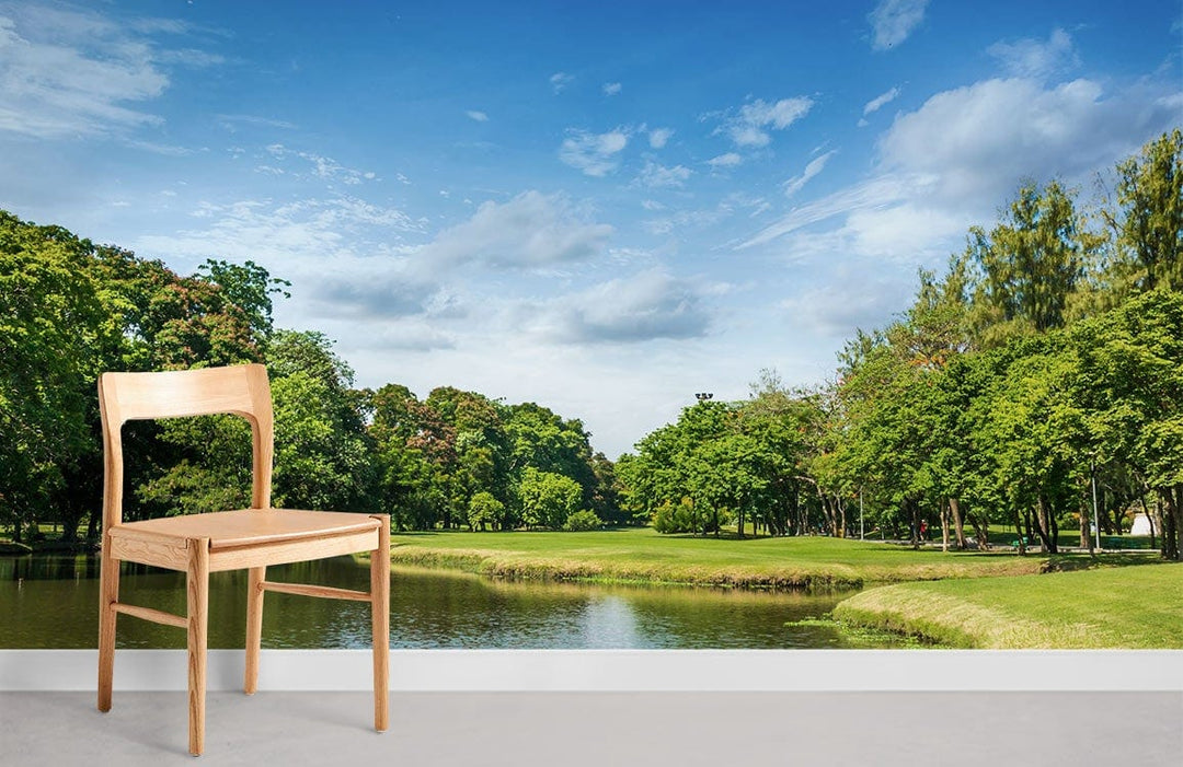 Wooden chair in front of green landscape mural wallpaper featuring blue sky reflection scene.