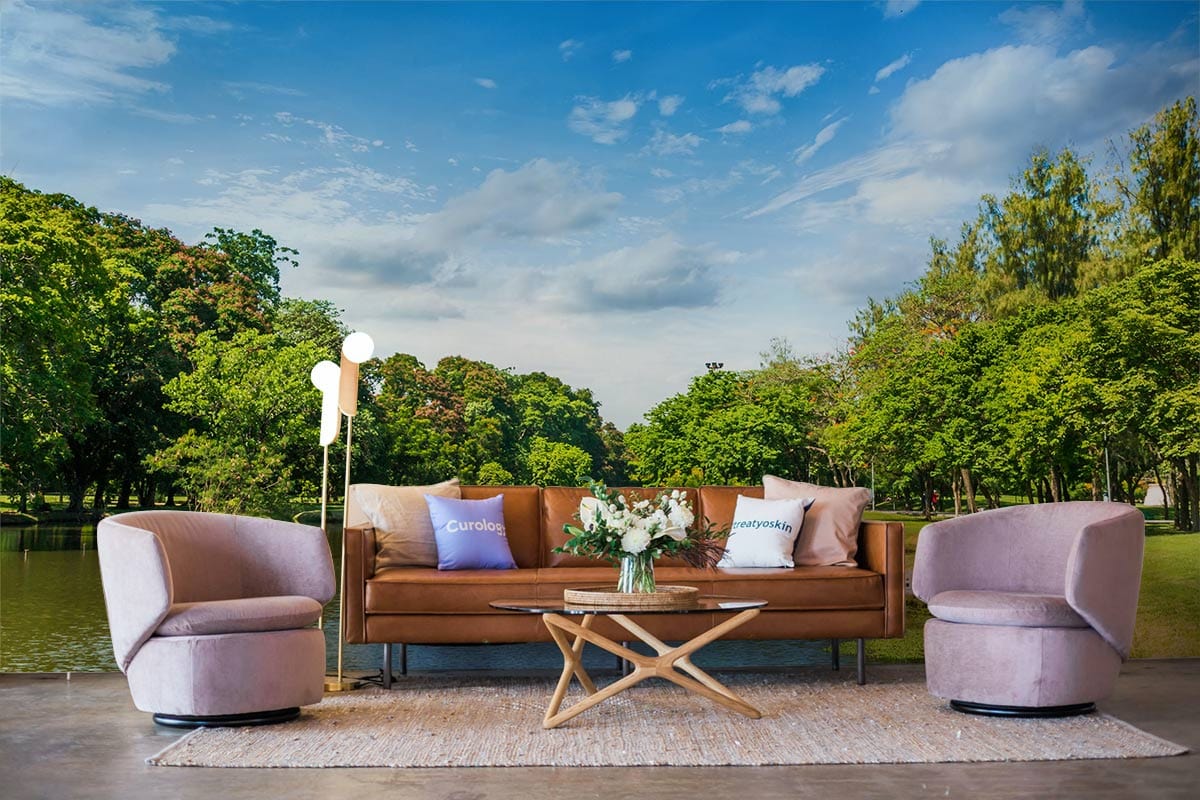Tranquil green landscape mural wallpaper features blue sky reflection, modern sofa, round chairs, and rug.