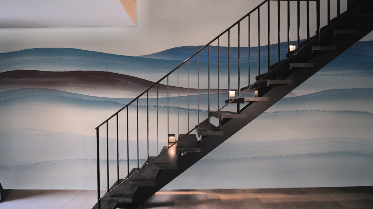 Tranquil blue watercolour mural wallpaper enhancing serene staircase with modern black railing, wooden flooring.