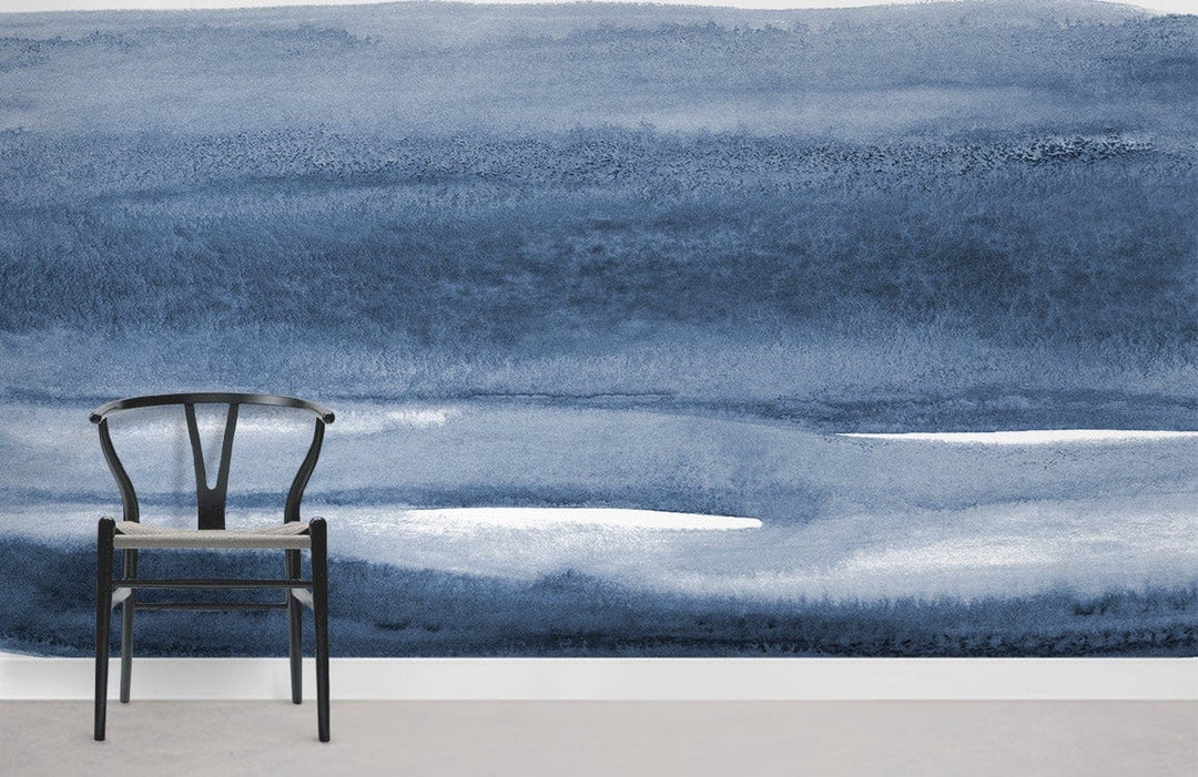 Blue Watercolour Horizon Mural Wallpaper with black chair in minimalist room, featuring grey flooring.