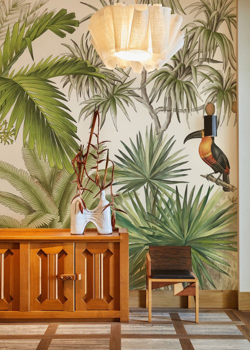 Tropical Jungle Paradise Wallpaper with toucan, wooden cabinet, chair, in botanical-themed room, geometric flooring.