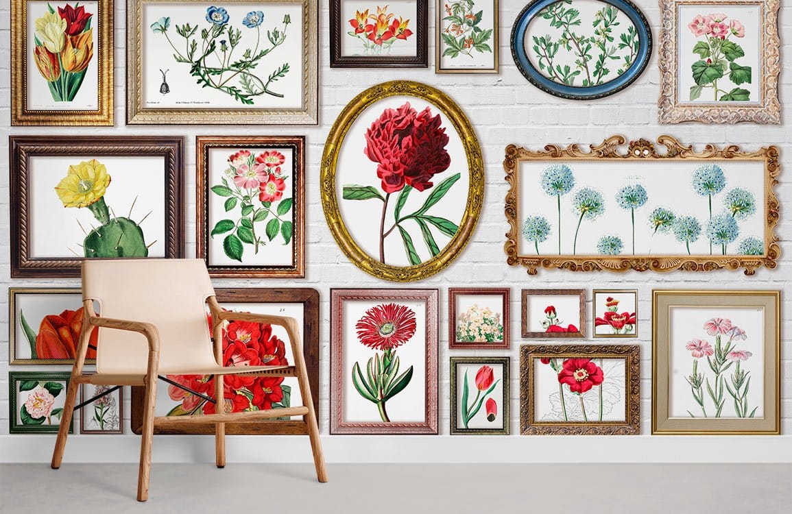 Vintage floral mural wallpaper with framed botanical art prints, beige chair, white wall, wooden flooring.
