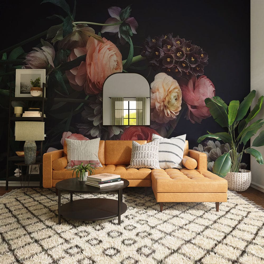 Moody floral wallpaper complements tan sofa, geometric rug, mirror, and elegant decor in stylish living room.