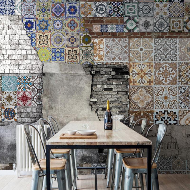 Vintage rustic patchwork mural wallpaper in dining room, featuring colourful geometric tile patterns and wooden table.