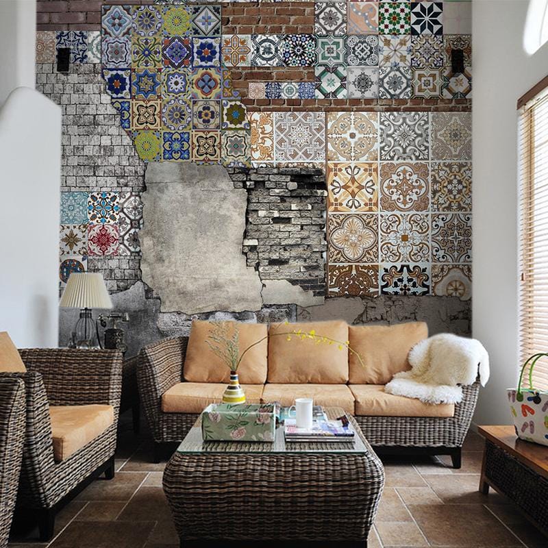 Vintage rustic patchwork mural wallpaper with geometric tiles; wicker furniture, tan sofa in living room.