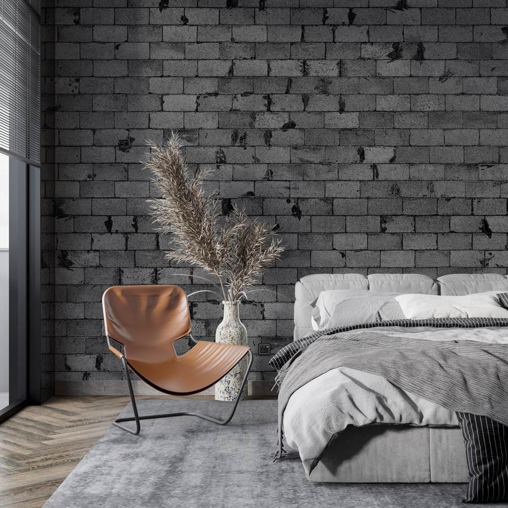 Urban Grey Brick Mural Wallpaper in stylish bedroom, featuring grey bed, brown chair, wood flooring.