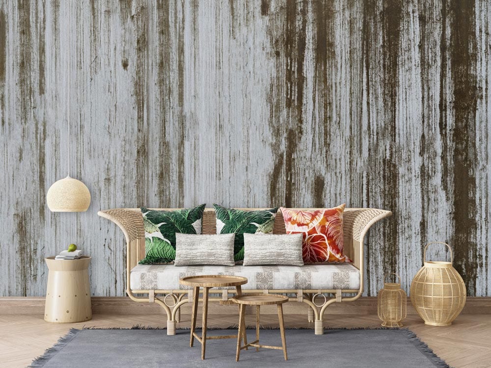 Industrial Chic rustic wallpaper complements wicker sofa, tropical cushions, parquet flooring, and modern decor elements.