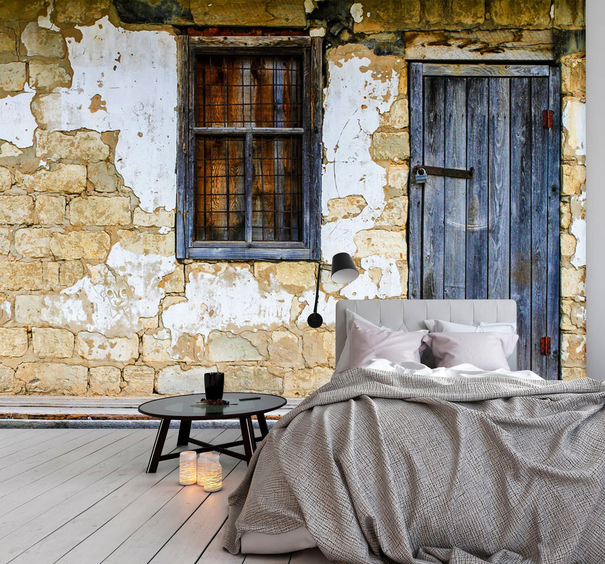 Rustic Stone Cottage Wall Mural, weathered door, window, grey sofa, wooden flooring in living room.